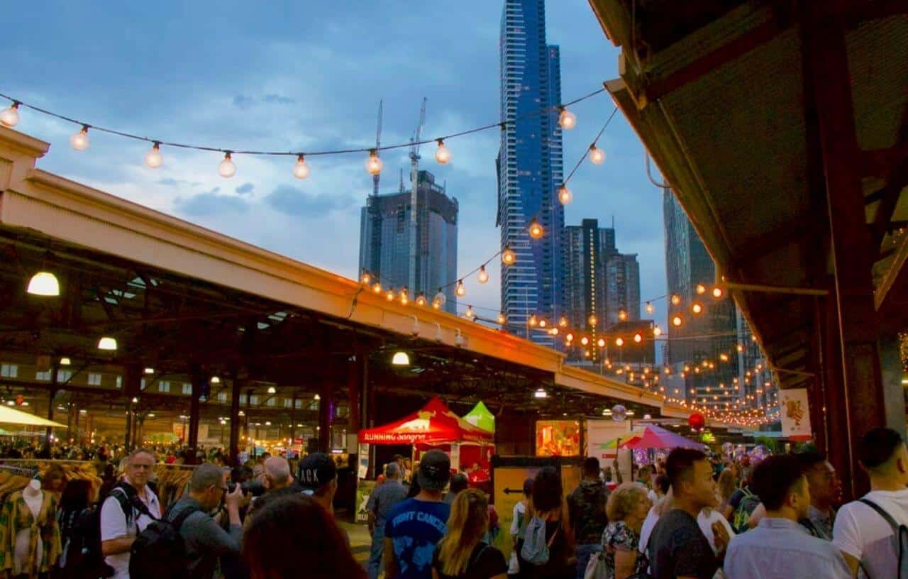 Evening photo of people shopping at Queen Victoria Market outdoors in Melbourne Australia